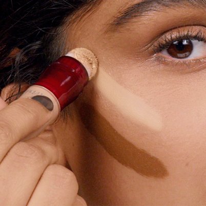 Woman applying Instant Age Rewind above cheek bone